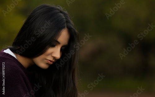 Melancholic pretty girl with straight hair in the outdoors