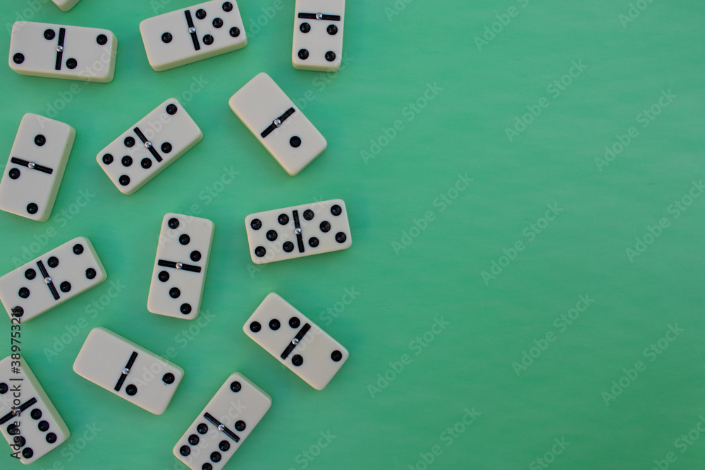 Deck of scattered dominoes on vibrant green background. Top down view flat lay with empty space for text Deck of scattered dominoes on vibrant green background. Top down view flat lay with empty space for text