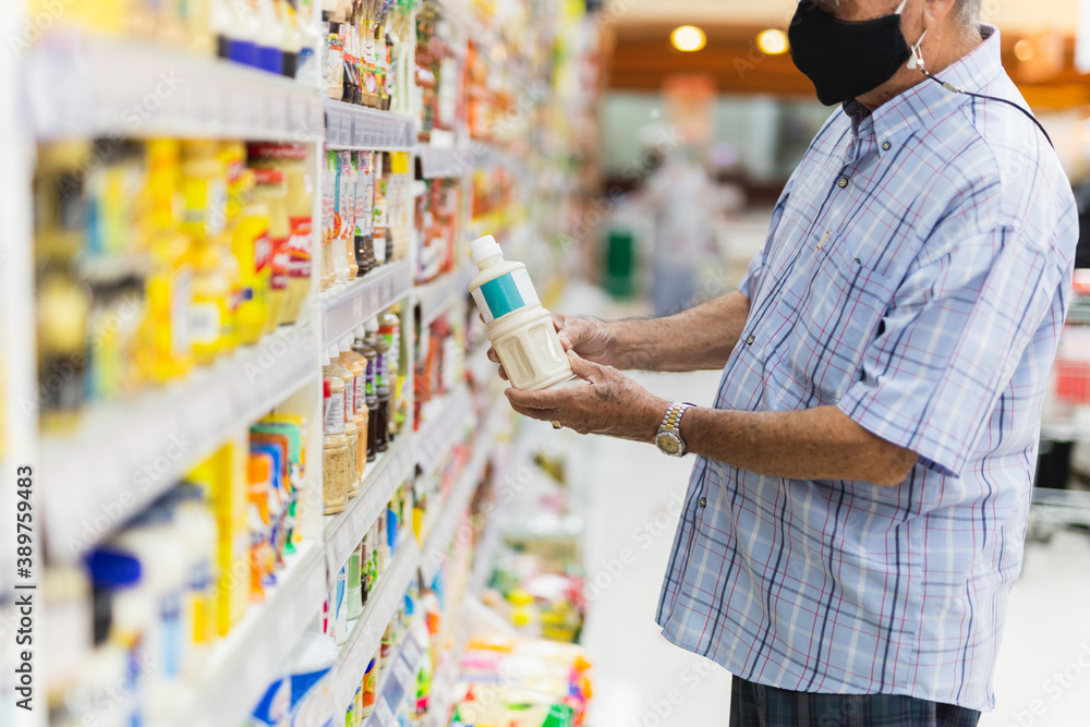 Senior man wearing a protective mask in food shopping store during Covid-19.