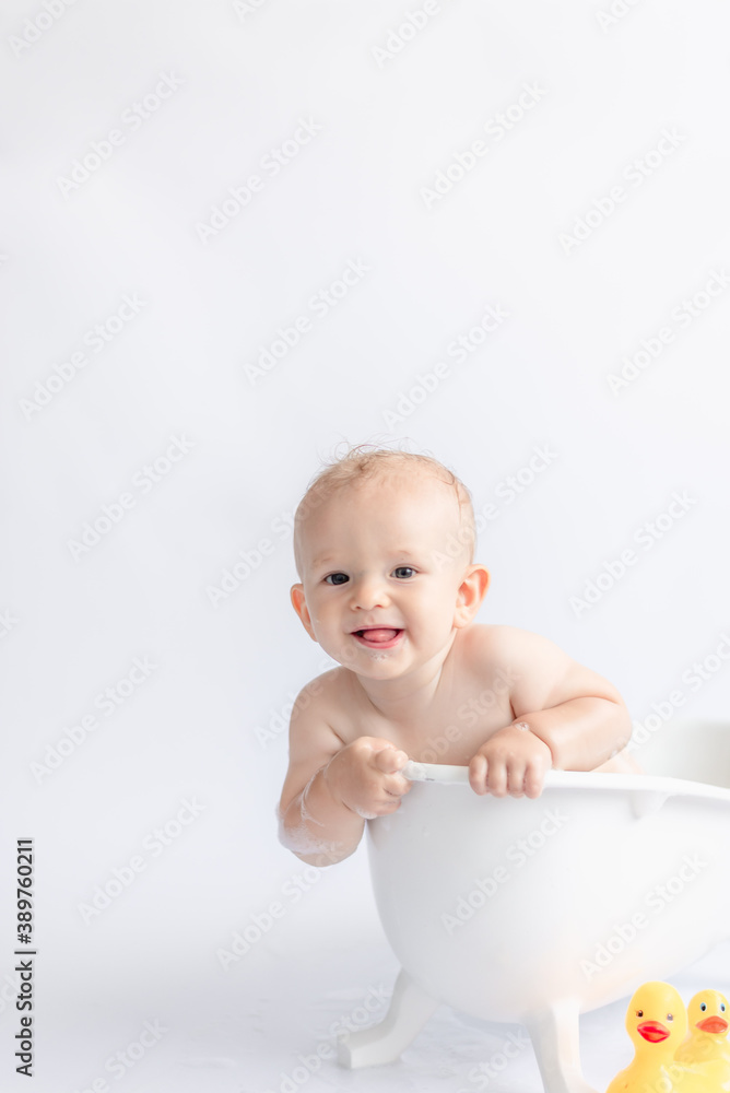happy baby bathes in white bathtub with rubber duckies happy baby bathes in white bathtub with rubber duckies