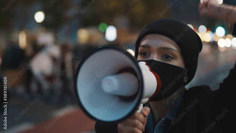A young girl in a medical mask speaks through a loudspeaker. Protest against abortion, protecting womens right. High quality photo A young girl in a medical mask speaks through a loudspeaker. Protest against abortion, protecting womens right. High quality photo