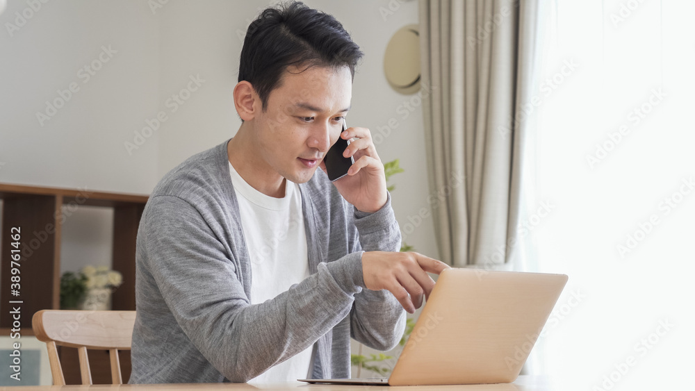リビングでパソコンをする男性 リビングでパソコンをする男性