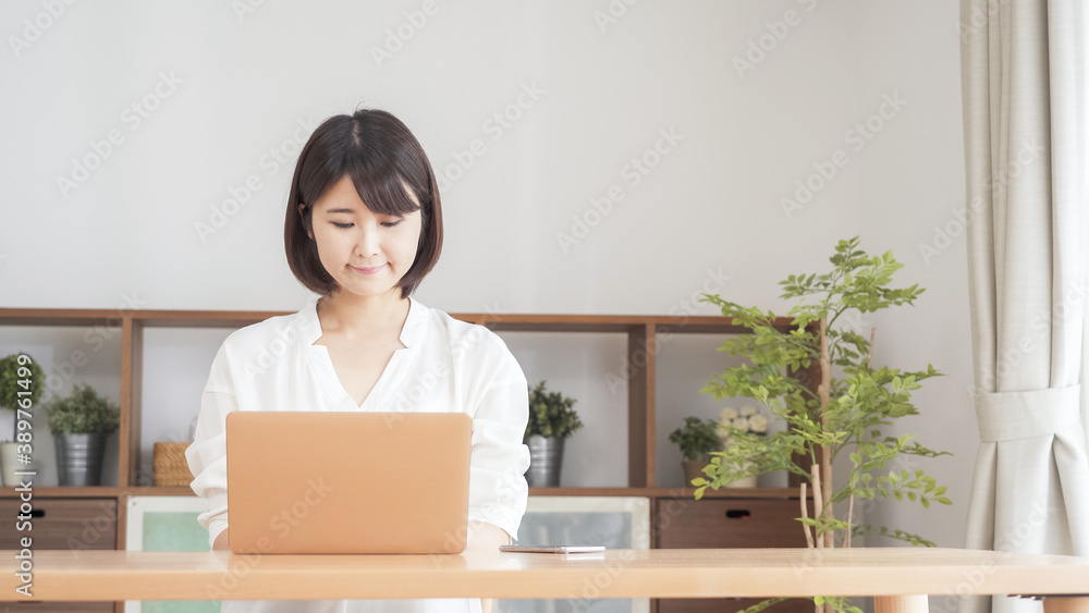リビングでパソコンをする女性 リビングでパソコンをする女性