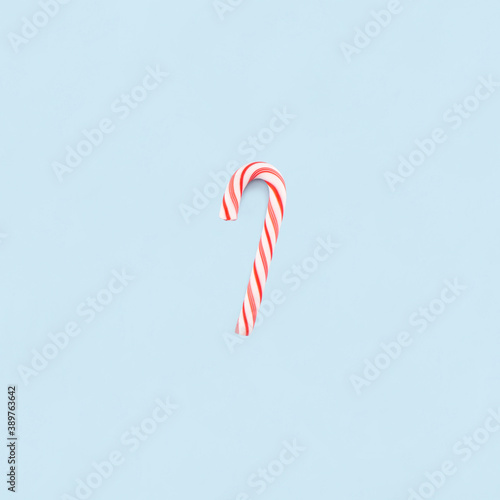 Christmas composition. Red and white candie on blue background. Christmas, winter, new year concept. Minimal style. Flat lay, top view, copy space.