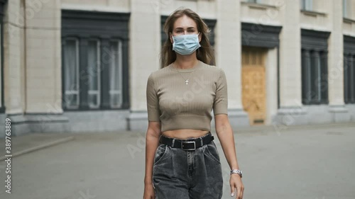 Woman in mask walk an Italian amphitheater. Looking at camera coronavirus covid 19. Masked girl near beautiful opera theater after pandemic covid-19. Person in masks walking street italy corona virus. photo