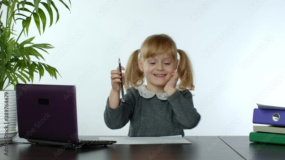 Back to school, online learning, distance lesson, education at home, technology for schoolgirl. Child girl with textbooks papers doing school homework and using laptop computer at home. 6k downscale Back to school, online learning, distance lesson, education at home, technology for schoolgirl. Child girl with textbooks papers doing school homework and using laptop computer at home. 6k downscale