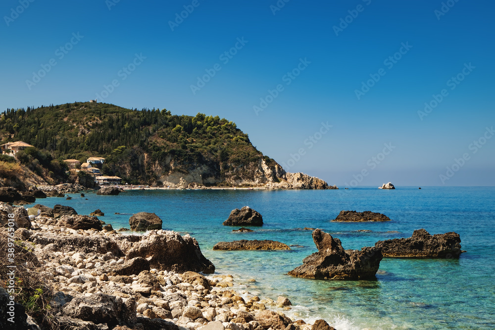 Idyllic summer sunny day on rocky Greek beach with beautiful turquoise sea water, panoramic landscape nature scenery in Lefkada island, Greece
