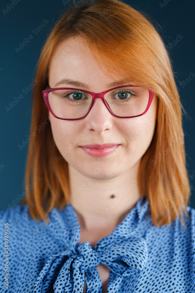 Close up portrait of adult caucasian woman in front of blue wall Close up portrait of adult caucasian woman in front of blue wall