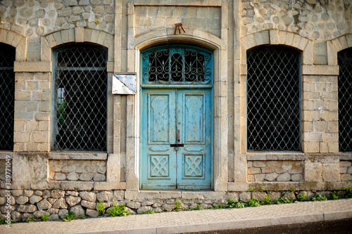 Old stone building with a blue wooden door in Karabagh photo