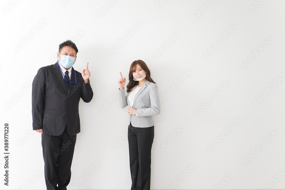 ソーシャルディスタンスを確保し、オフィスで会話をするビジネスパーソン