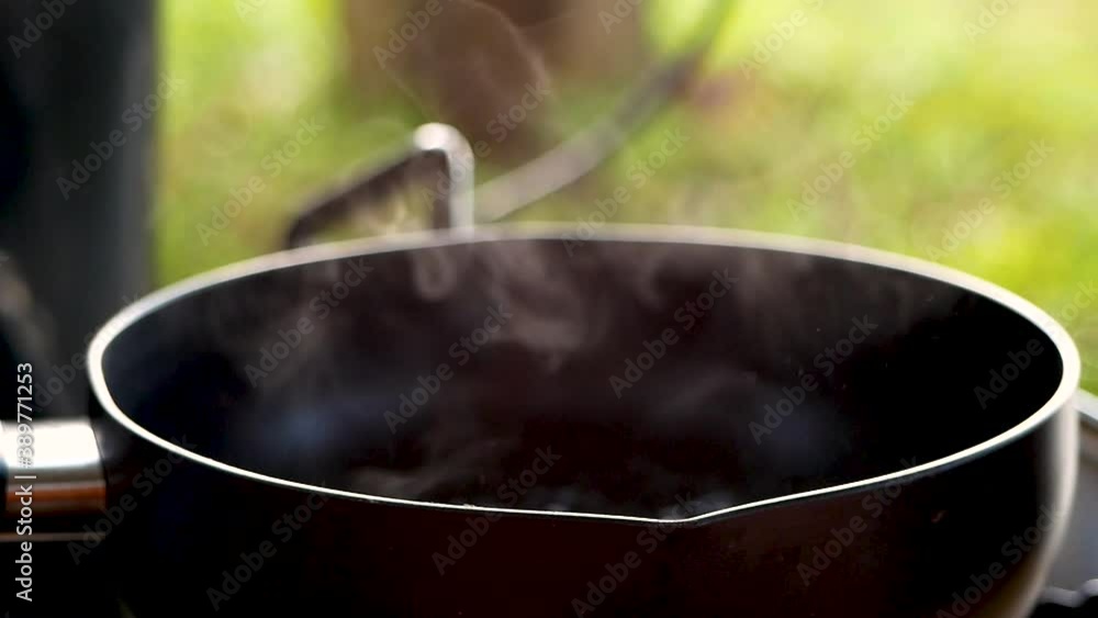Close-up of Boiling water in a pan with steam on a gas burner in breakfast at the camping. Traditional cooking. Concept of lifestyle in vacation. Close-up of Boiling water in a pan with steam on a gas burner in breakfast at the camping. Traditional cooking. Concept of lifestyle in vacation.