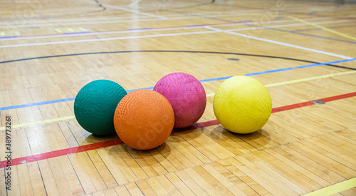 Fotografiet Gros plan sur quatre ballons au sol d'un gymnase