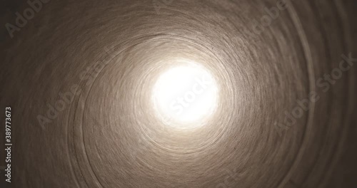 Moving through a tube tunnel with bright light shining at the end, probe lens motion