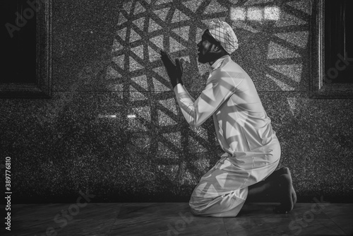 muslim man having worship and praying in islam ceremony in mosque