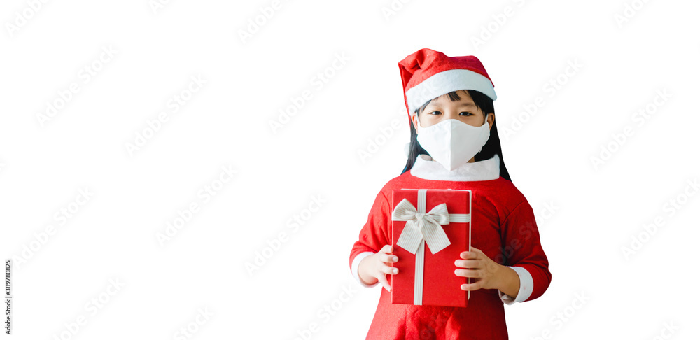 Fototapeta premium Christmas during coronavirus covid19.Little asian girl wearing mask holding gift box isolated on white banner.Christmas winter celebration at home.New normal, Social distancing, Christmas present.