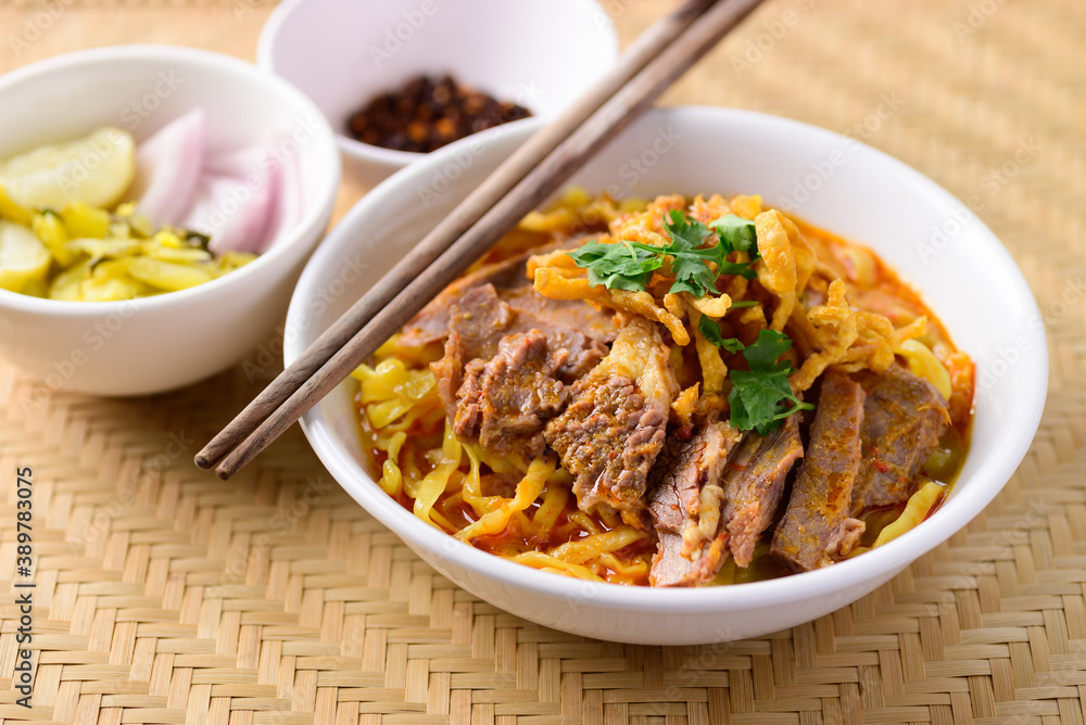 Northern Thai food (Khao Soi), Spicy curry noodles soup with beef eating with pickled mustard, shallot, lime and ground chili fried in oil
