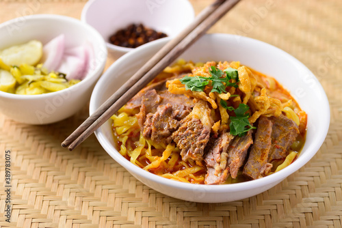 Northern Thai food (Khao Soi), Spicy curry noodles soup with beef eating with pickled mustard, shallot, lime and ground chili fried in oil