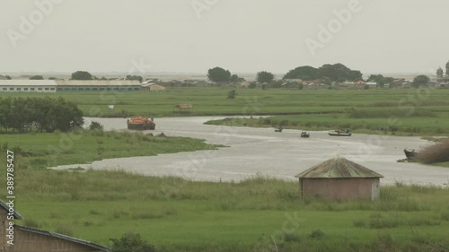 Barge carrying good on a river in Benin with pirogues photo