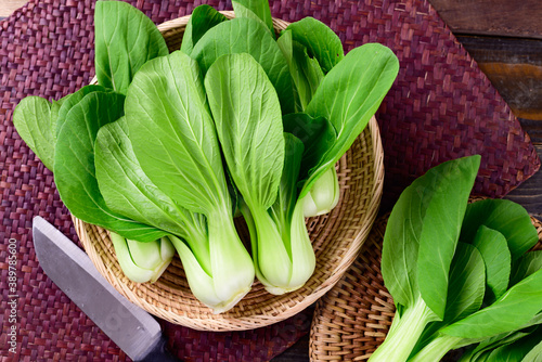 Fresh Bok Choy or Pak Choi (Chinese cabbage) in bamboo basket on wooden background, Organic vegetables, Top view
