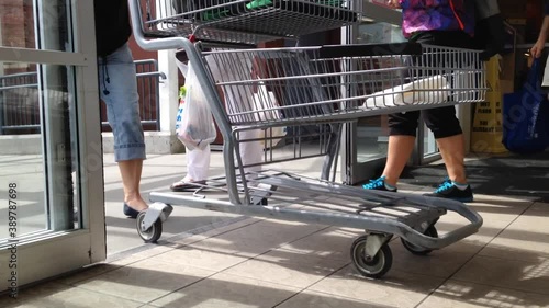 People with Shopping Cart Walking Through the Doors of the superstore