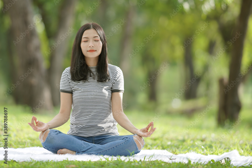 Young woman in white and black strip t-shirt and long pants do meditation in park. Young woman in white and black strip t-shirt and long pants do meditation in park.