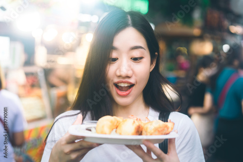  Happy young adult asian travel and eating street food.