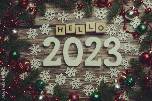 Hello 2023 alphabet letters with Christmas decoration on wooden background © may1985