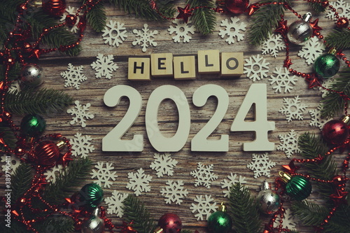 Hello 2024 alphabet letters with Christmas decoration on wooden background © may1985