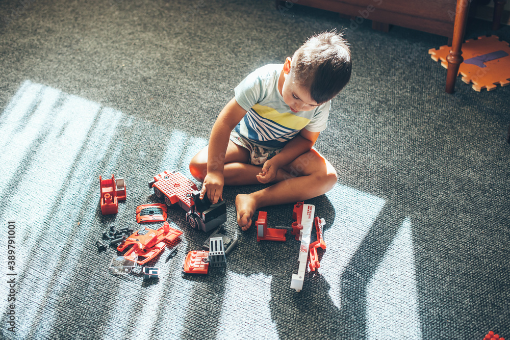 Upper view photo of a caucasian boy playing on the floor with ...