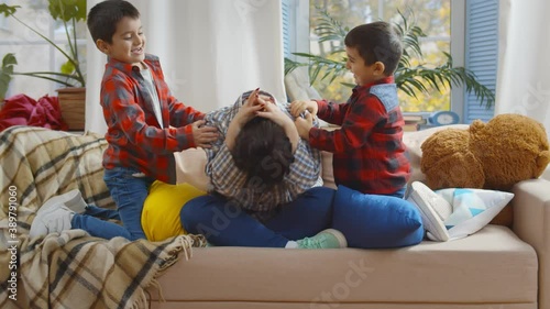 Tired mother feels exhausted while noisy little kids annoying her