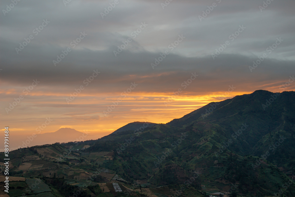 Sikunir mountain silhouette against the background of the red sunrise sky. enjoy the morning in the dieng plateau