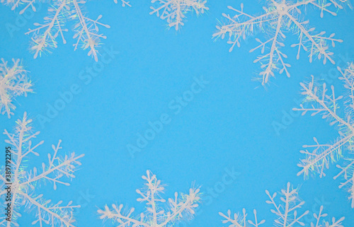 White snowflakes on a blue background. Christmas background. Christmas flat lay.