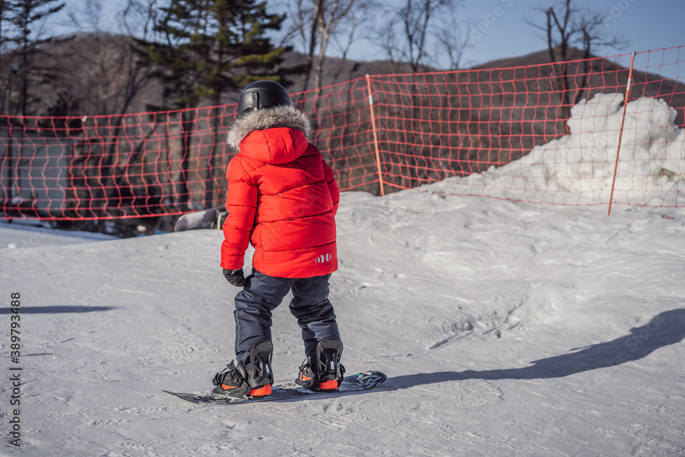 Little cute boy snowboarding. Activities for children in winter. Children's winter sport. Lifestyle