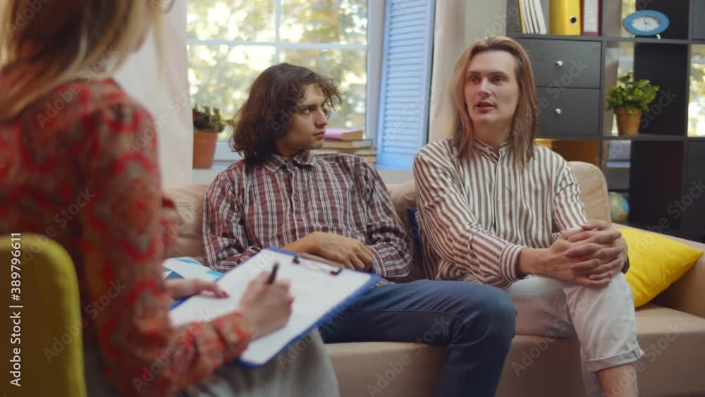 Married caucasian couple of two men having therapeutical meeting at psychologist office Married caucasian couple of two men having therapeutical meeting at psychologist office
