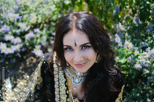 Woman in ethnic indian costume with gold jewellery and traditional makeup.