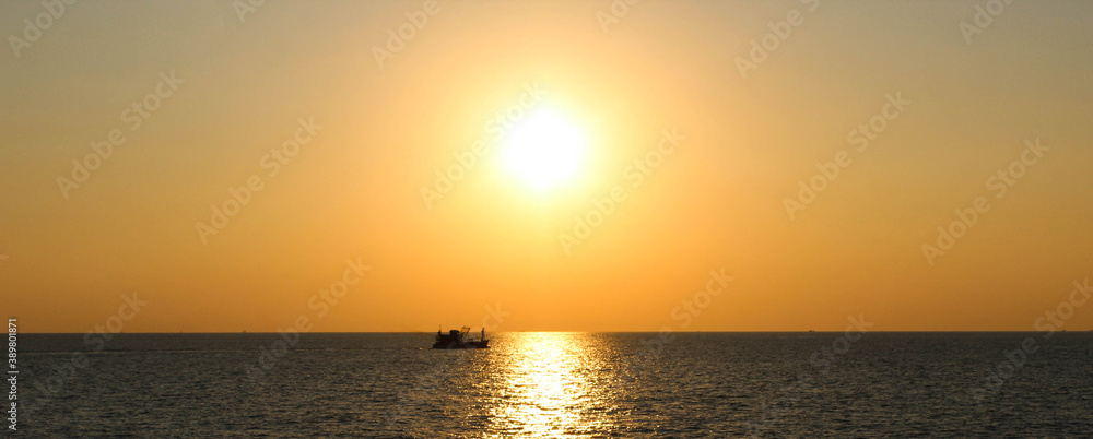 Little Ship in the ocean with the sunset moment