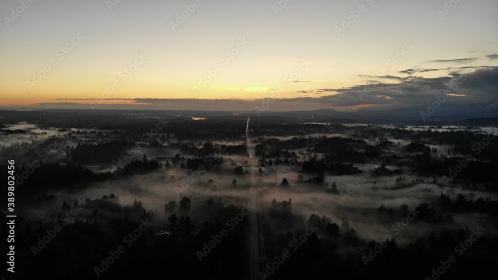 sunset over rural area with fog on the ground