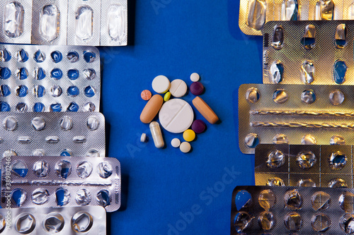 Empty used blister package and different pills on blue background