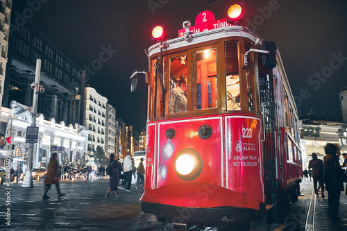 Vintage tram at Taksim Square in the rainy evening. Istanbul, Turkey - December 2019 photo