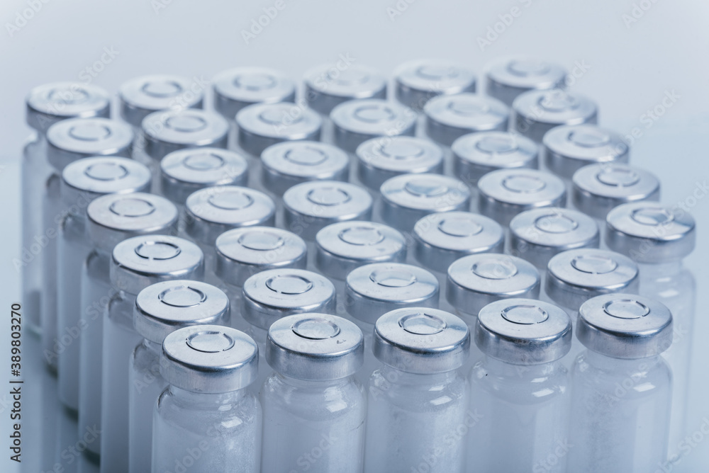 Glass medical ampoule vial for injection. Medicine is dry white drug penicillin powder or liquid with of aqueous solution in ampulla. Close up. Bottles ampule with aluminum cap on backgrounds gray. Glass medical ampoule vial for injection. Medicine is dry white drug penicillin powder or liquid with of aqueous solution in ampulla. Close up. Bottles ampule with aluminum cap on backgrounds gray.