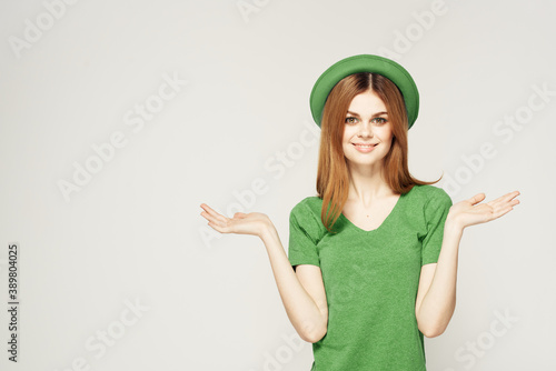 girl in green clothes with hat on light background St. Patrick's day cropped view
