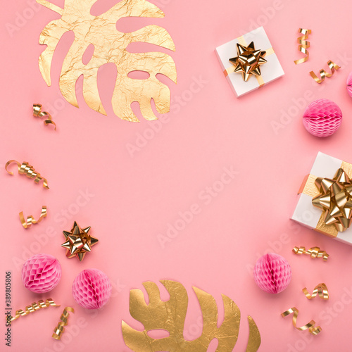 Golden tropical leaves Monstera  festive gift box  gold and pink decorations on amaranth pink background.