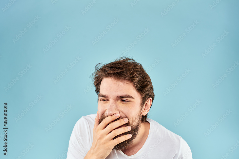 Emotional man with a beard in a white t-shirt blue background fun lifestyle