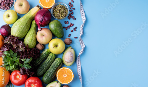 Fresh vegetables and fruit for healthy diet and a measuring tape top view flat lay with copy space