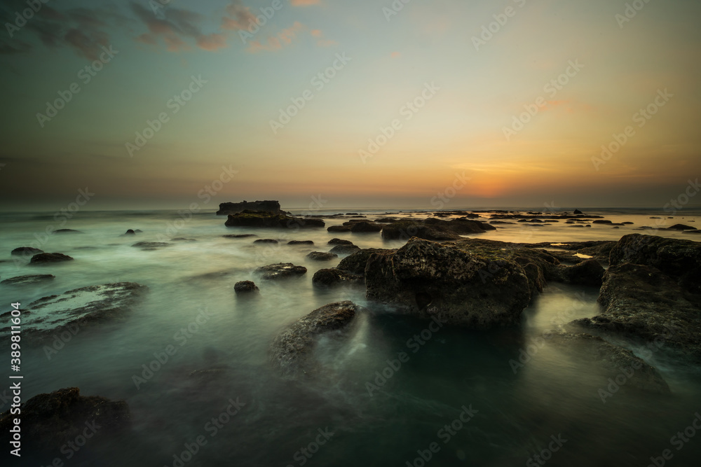 Amazing seascape. Landscape background. Beach with rocks and stones. Low tide. Motion water. Slow shutter speed. Soft focus. Mengening beach, Bali, Indonesia