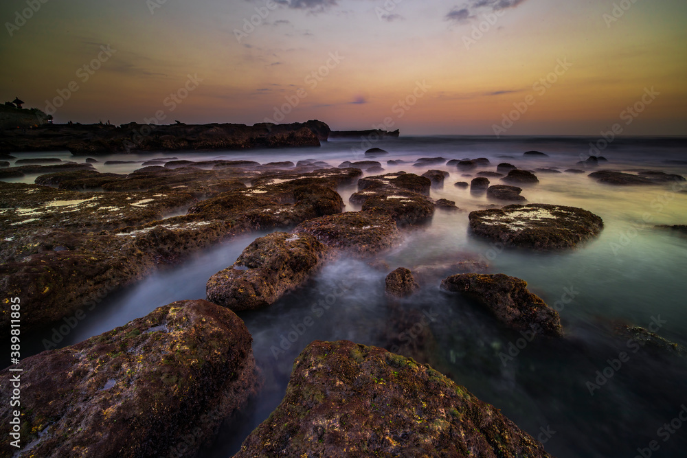Amazing seascape. Landscape background. Beach with rocks and stones. Low tide. Motion water. Slow shutter speed. Soft focus. Mengening beach, Bali, Indonesia
