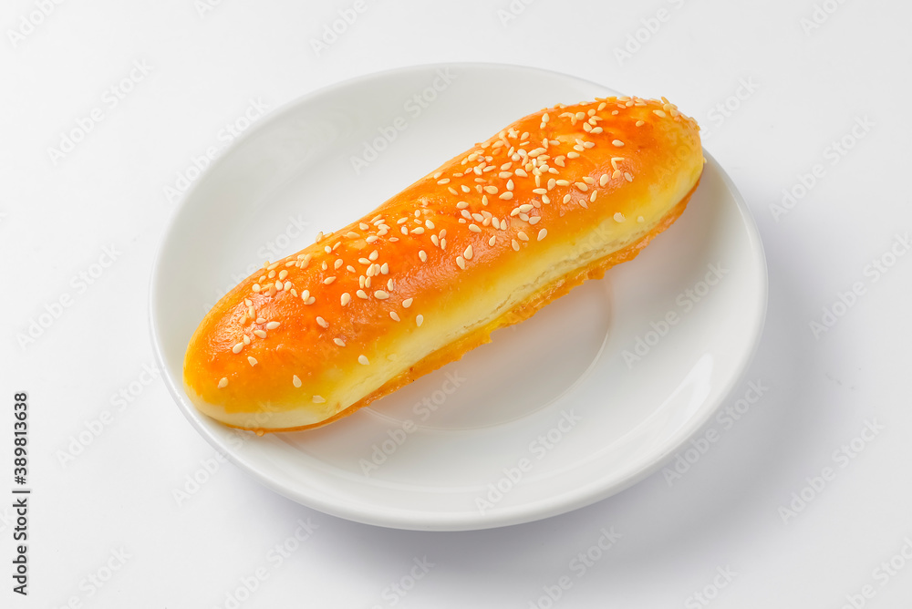 Buttermilk dinner bun served on a white plate over white background. Buttermilk dinner bun served on a white plate over white background.