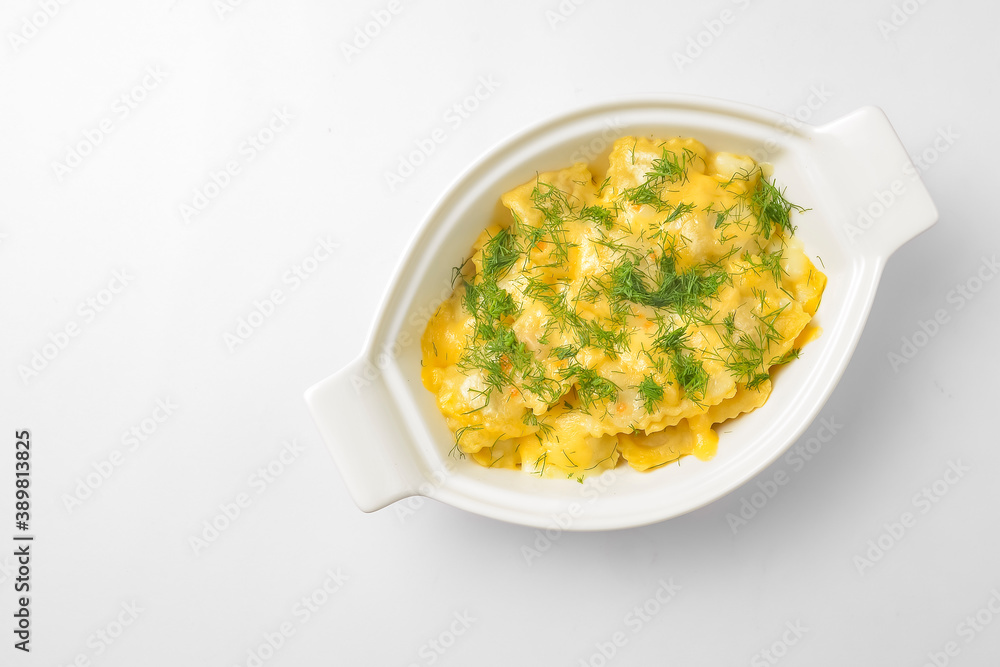 Ravioli dumpling with fresh greenery served in a white pot over white background. Isolated on white. Ravioli dumpling with fresh greenery served in a white pot over white background. Isolated on white.