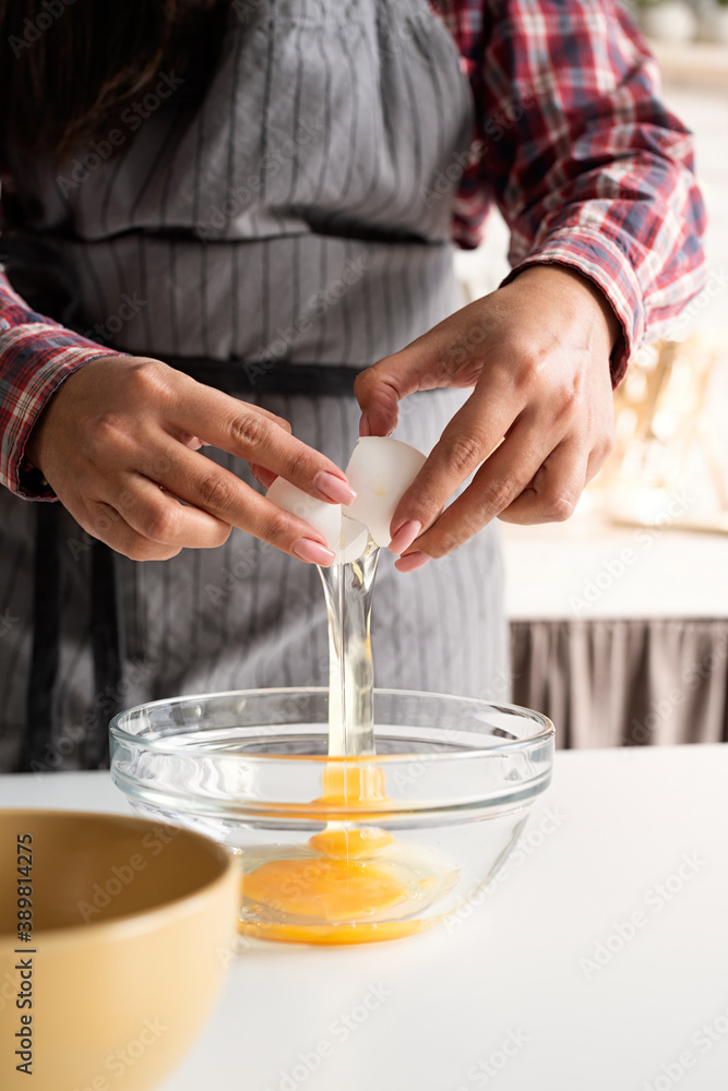 woman hands cracking the egg in the kitchen woman hands cracking the egg in the kitchen