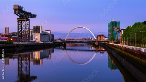 Glasgow, Scotland. View of Glasgow, UK landmarks - Finnieston Crane and Squinty bridge at sunset. Time-lapse with the colorful twilight sky, zoom in